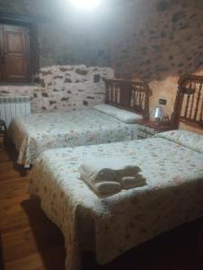 a bedroom with two beds with towels on them at Rincón del Bierzo in Borrenes