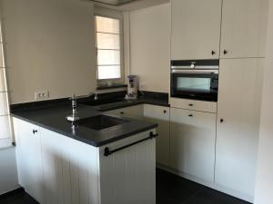 eine Küche mit Spüle und Mikrowelle in der Unterkunft Merida in Knokke-Heist