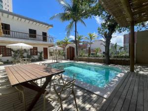 eine Terrasse mit Tisch und Swimmingpool in der Unterkunft Villa da Praia -Orla de Atalaia in Aracaju