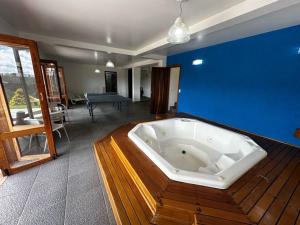 bañera grande en una habitación con pared azul en Chalé Luxuoso Capivari em Campos do Jordão, en Campos do Jordão 37 fotos más