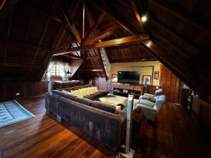 sala de estar amplia con sofá grande y sillas en Chalé Luxuoso Capivari em Campos do Jordão, en Campos do Jordão