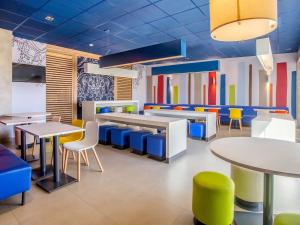 a dining room with tables and chairs and colorful walls at Ibis Budget Uberlândia in Uberlândia