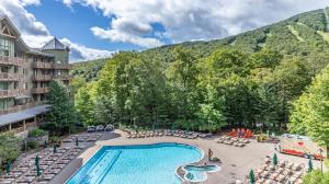Blick auf ein Hotel mit Pool und Berge in der Unterkunft #337 Inside Lodge At Spruce Peak Studio Ski in in Ski out By Stowe Mountain Rentals in Stowe