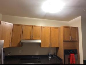 uma cozinha com armários de madeira e uma luz no tecto em Private Room and Bathroom in Revere em Revere
