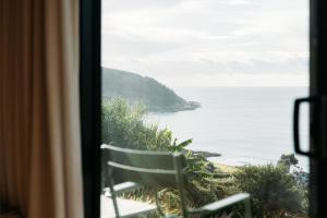 a view of the ocean from a window at The Huts in Ahipara +9 photos