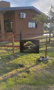 ein Schild im Gras vor einem Haus in der Unterkunft Cabaña Cina Cina in Villa Larca