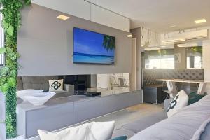 TV a/nebo společenská místnost v ubytování Conforto na Praia Gonzaga, Estacionamento, Piscina