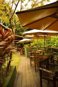 a patio with tables and chairs and umbrellas at Bela Vista Lodge in Novo Airão +37 photos