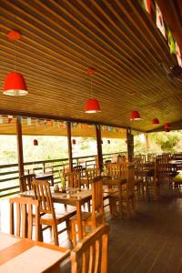 a restaurant with wooden tables and chairs and red lights at Bela Vista Lodge in Novo Airão