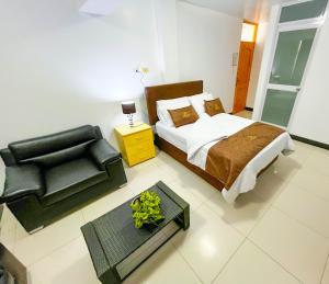 a bedroom with a bed and a chair and a table at Hotel Orlak in Huancayo