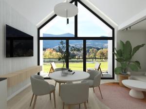 - un salon avec une table, des chaises et une grande fenêtre dans l'établissement Top Escape - apartamenty z widokiem na góry - Przycup w Karkonoszach Apartamenty, à Karpacz