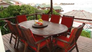 a wooden table with chairs and a bowl of fruit on it at TussenIn in Eersterivierstrand +14 photos