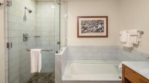 une salle de bain blanche avec une baignoire et une douche dans l'établissement 374 Lodge At Spruce Peak Ski In Ski In Ski Out King Studio By Stowe Mountain Rentals, à Stowe 11 autres photos