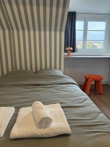 - un lit avec 2 serviettes et une fenêtre dans l'établissement Charmant appartement - Le Dopamine, à La Roche-sur-Yon