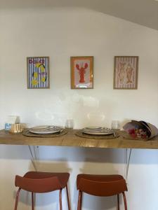 une table avec deux chaises et des assiettes et des verres dessus dans l'établissement Charmant appartement - Le Dopamine, à La Roche-sur-Yon