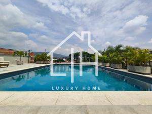 Un cartel que dice casa de lujo junto a una piscina. en Cali - Apartaestudios Edificio Miro Living Refugio, en Cali 26 fotos más
