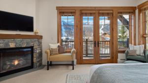 a bedroom with a fireplace and a television and a bed at STOWE GLOBE 4 BEDROOM LUXURY CABIN SKI IN SKI OUT By Stowe Mountain Rentals in Stowe