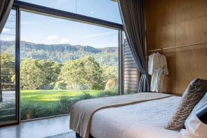 a bedroom with a large window with a view of a mountain at Willow at Barranca - Luxury Villa in Barrengarry