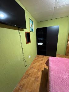 a room with a bed and a television on the wall at Apartment house FIDE in Panajachel