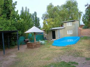 a backyard with a house and a blue pool at Casa Entre Viñas in Ciudad Lujan de Cuyo