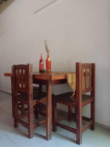 einen Holztisch mit zwei Stühlen und zwei Flaschen in der Unterkunft Mononorte in Mar de Ajó