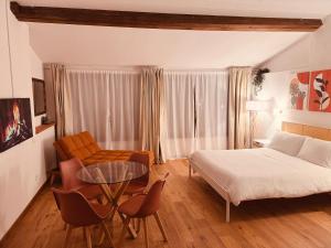 多尔切阿夸Il Nido - Guest house的一间卧室，里面有一张床、一张桌子和几把椅子。