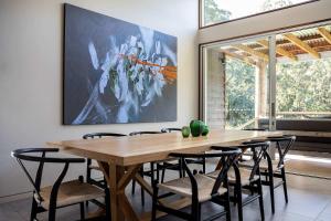 a dining room with a wooden table and chairs at Ferndale at Barranca - Luxury Villa in Barrengarry