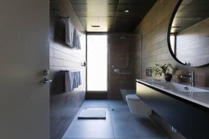 a bathroom with a sink and a toilet and a mirror at Ferndale at Barranca - Luxury Villa in Barrengarry