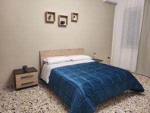 a bedroom with a blue bed and a wooden night stand at Panoramic Tower in Torre del Greco