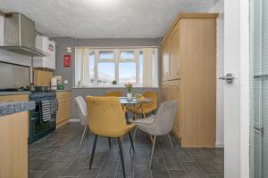 eine Küche mit einem Tisch und Stühlen in einer Küche in der Unterkunft The Randolph 2-Bed MK9 Flat Short- Long-Stay Family & Contractor Friendly Free Parking close to Theatre, Now with lounge in Milton Keynes