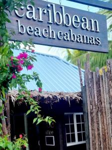 a sign that reads carilliben beach calahuas at Caribbean Beach Cabanas in Placencia Village
