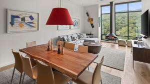 un salon avec une table et des chaises en bois dans l'établissement New Spruce Peak Tree House Unit Steps To The Lifts With Big Mountain Views Sleeps 9 By Stowe Mountain Rentals, à Stowe