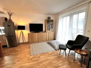 a living room with a television and a chair at Apartmán Mařinka in Říčky
