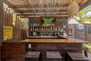 a bar with a wooden counter and some bottles of alcohol at Caribbean Beach Cabanas in Placencia