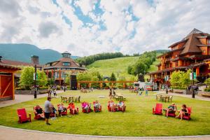 Un groupe de personnes assises sur l'herbe dans l'établissement 409 3 bed Treehouse unit Spruce Peak at the Base of Stowe Mt Resort sleeps 9, à Stowe