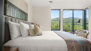 une chambre avec un grand lit et une grande fenêtre dans l'établissement 409 3 bed Treehouse unit Spruce Peak at the Base of Stowe Mt Resort sleeps 9, à Stowe
