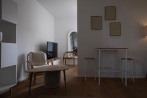 a living room with a table and chairs and a desk at Modernes 1-Zimmer-Studio I Augsburg City in Augsburg