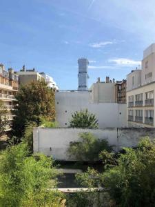 a view of a building with a chimney in a city at The Artist in Clichy