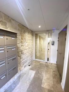 a room with a stone wall and a door at The Artist in Clichy