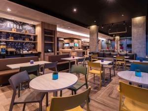 un restaurante con mesas y sillas y un bar en ibis Chia, en Chía