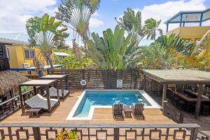 a swimming pool with chairs and a table and a table and chairsitures at Caribbean Beach Cabanas in Placencia Village +56 photos