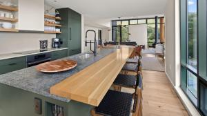 une cuisine avec des placards verts et un comptoir en bois dans l'établissement 411 Spruce Peak Stowe Mountain Resort New Treehouse unit Ski in Ski out 4 bed sleeps 12, à Stowe Mountain