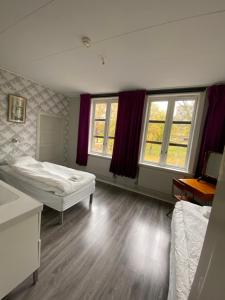 a bedroom with two beds and two windows at Kungälvs Bed & Brekfast in Kungälv