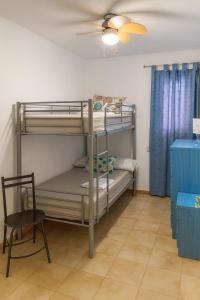 Zimmer mit 2 Etagenbetten und einem Stuhl in der Unterkunft Duplex familiar in Puerto de Mazarrón