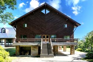a large wooden barn with a ramp leading up to it at みみずく山荘 Mimizuku Lodge in Myoko
