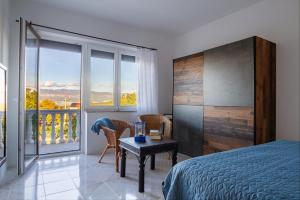 a bedroom with a bed and a table and a balcony at Apartman Kačić in Sveti Ivan Dobrinjski