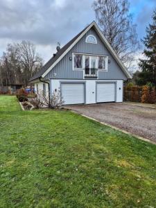 a house with a garage with a grass yard at Toftahöjden 7 in Växjö
