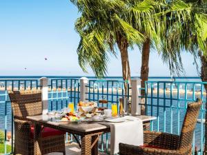 una mesa con comida en un balcón con vistas al océano en Movenpick Resort & Spa El Gouna, en Hurghada 124 fotos más