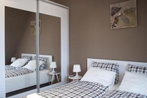 a bedroom with two beds and a mirror at Flat with Unforgettable View in Budapest