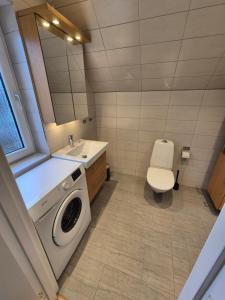 a bathroom with a washing machine and a toilet at Toftahöjden 7 in Växjö +7 photos